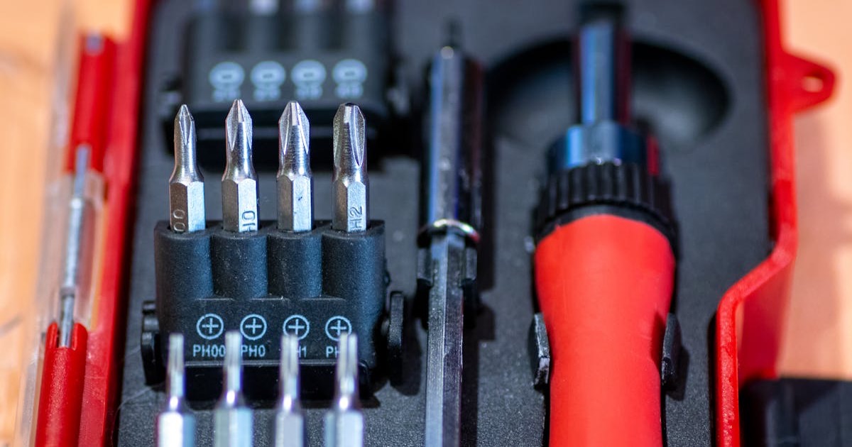 Detailed view of a screwdriver set in a red case, featuring interchangeable bits and tools.